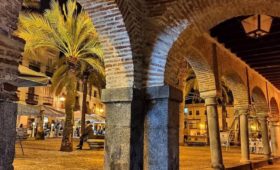Plaza iluminada con arcos y palmeras. Plaza Grande de Zafra